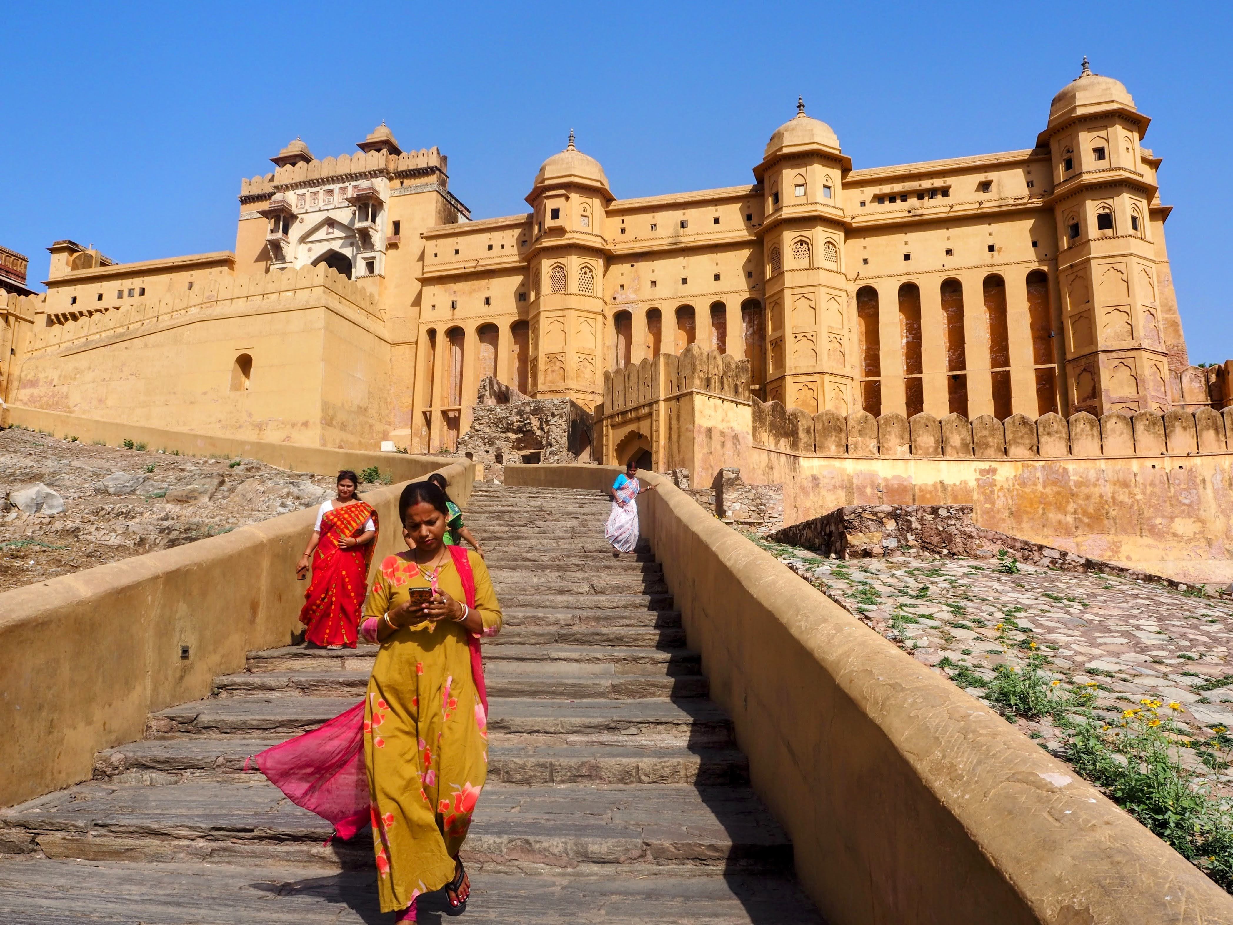 Visitors ascending the steps of Amber Fort in colourful saris, Jaipur